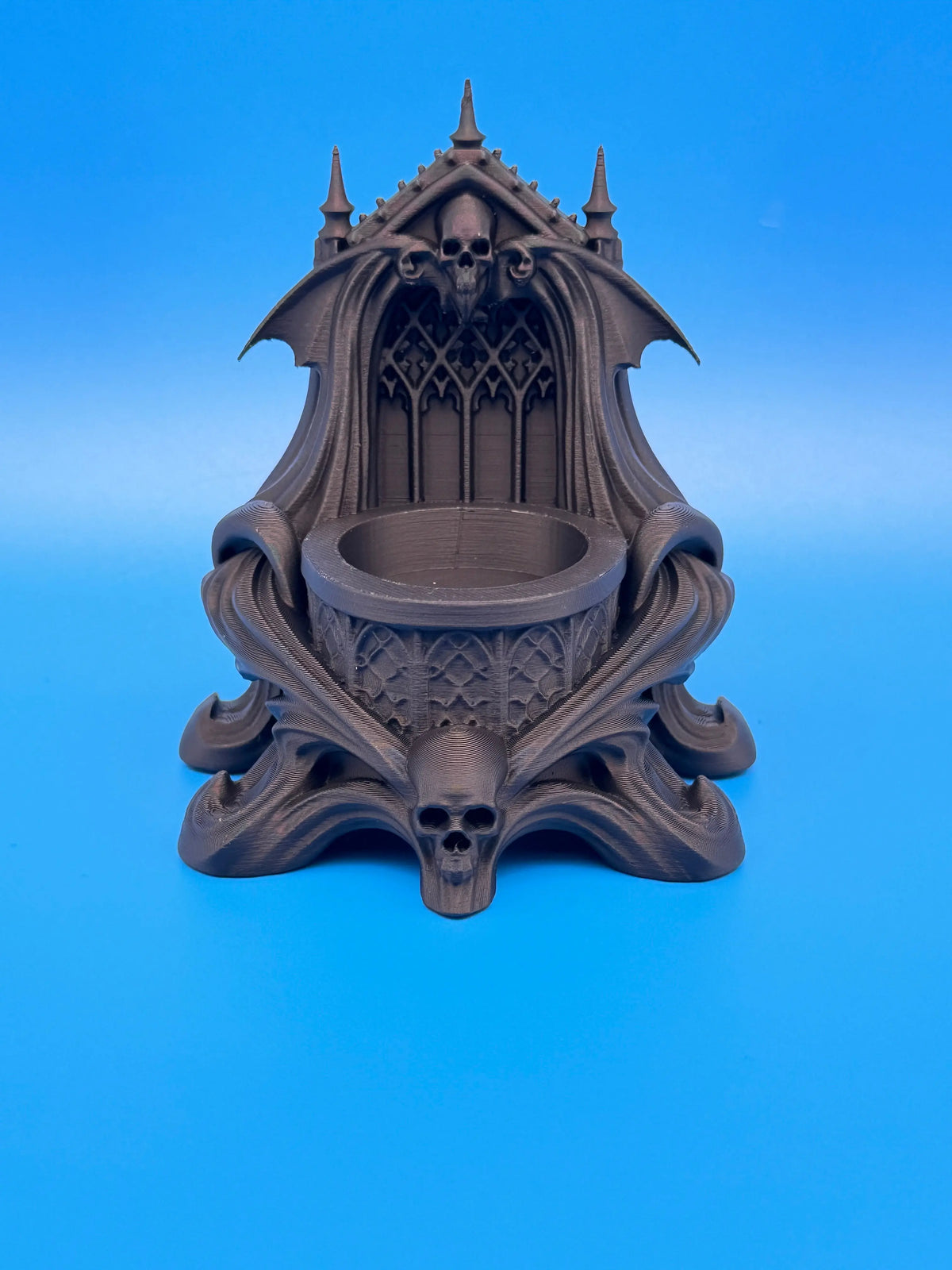 Matte black gothic skull and bat LED tealight holder with glowing flameless candle and ornate cathedral-style details.